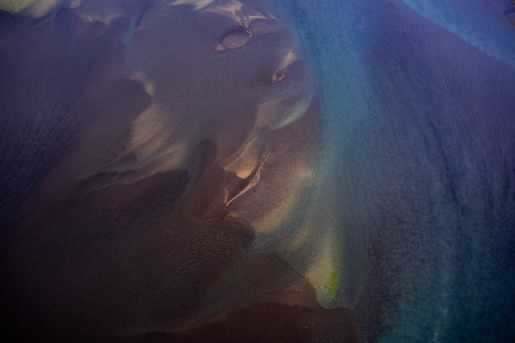Sediment-laden glacial rivers in Iceland, seen from above, creating striking abstract patterns