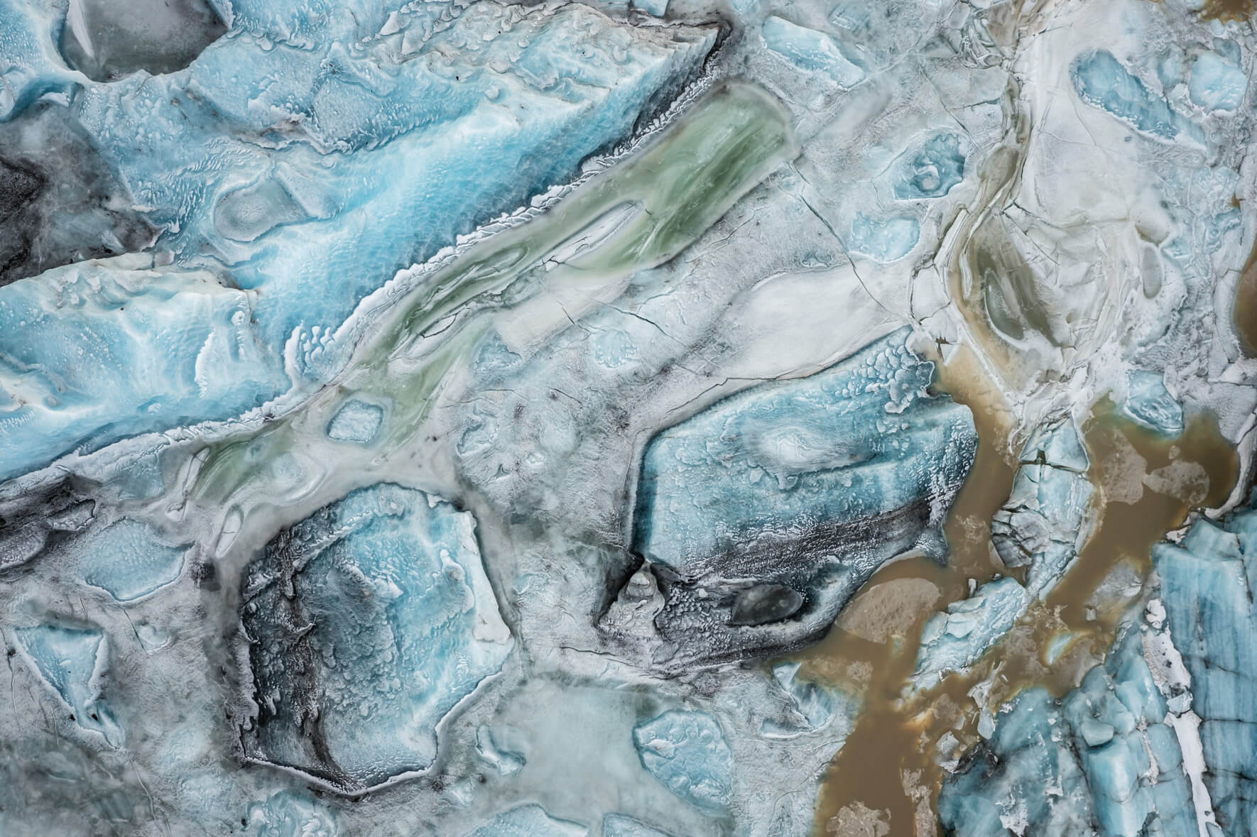 Aerial view of Svínafellslón glacial lagoon in Iceland, showcasing vibrant ice textures and colors