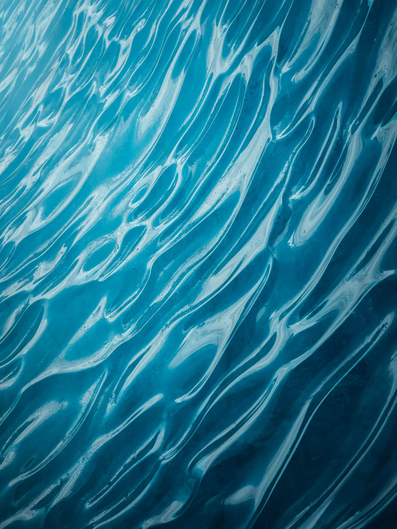 Interior of a glacier ice cave in Iceland, shaped by time, melting, and refreezing