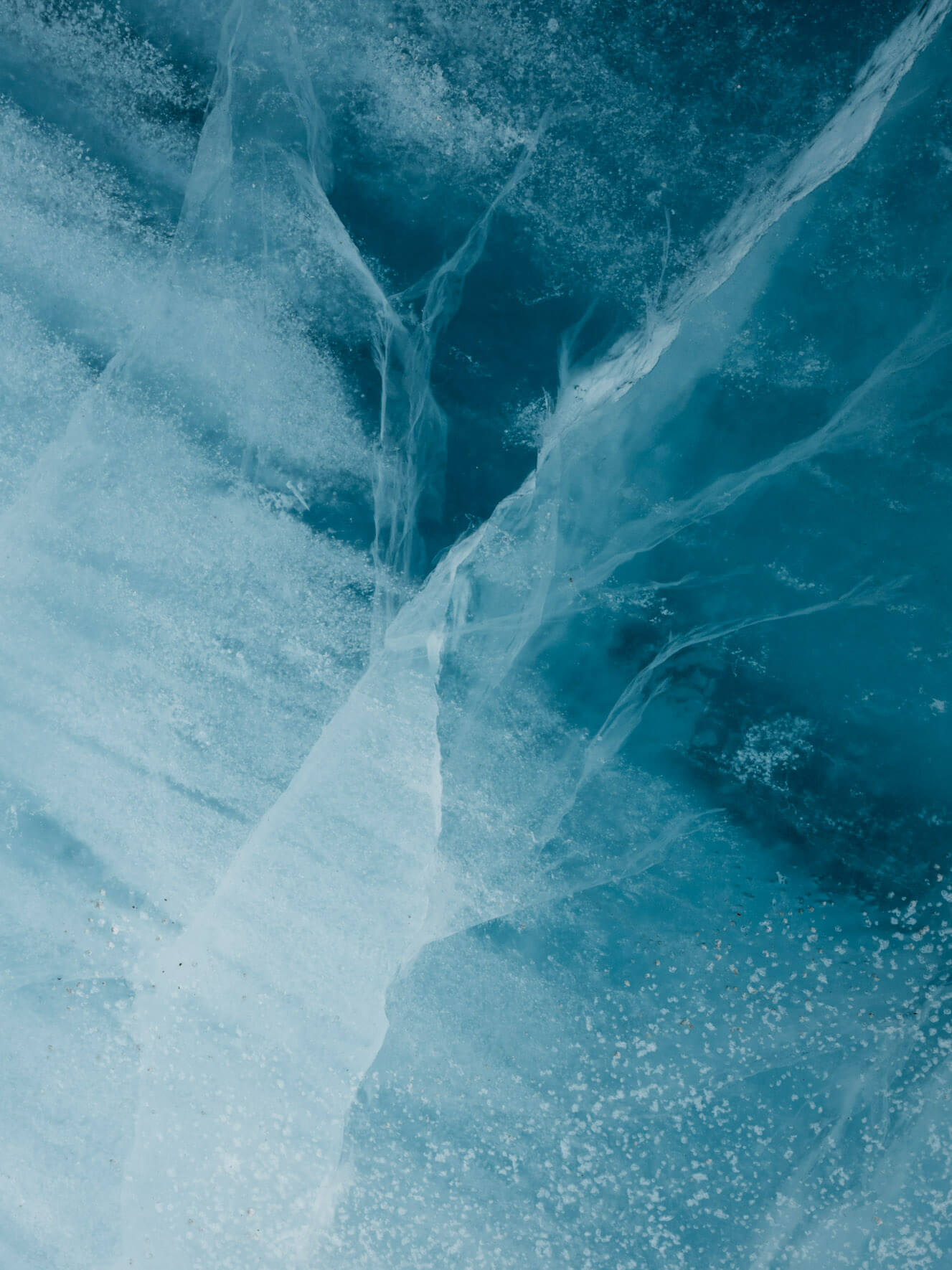 Glass-like glacier ice inside an iceberg, showcasing polished surfaces and intense blue tones