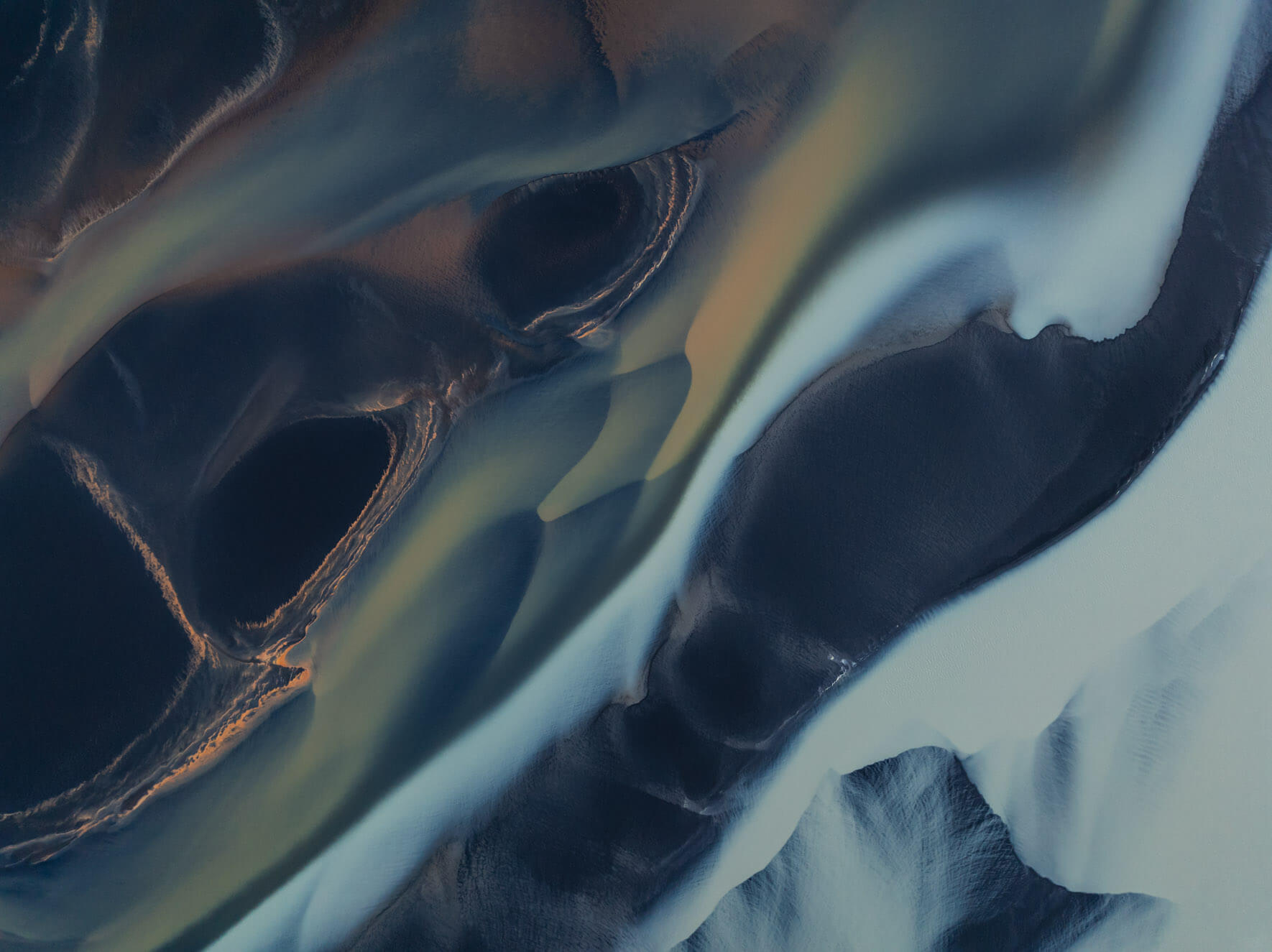 Aerial perspective of Iceland’s glacial rivers highlighting milky water and golden hues