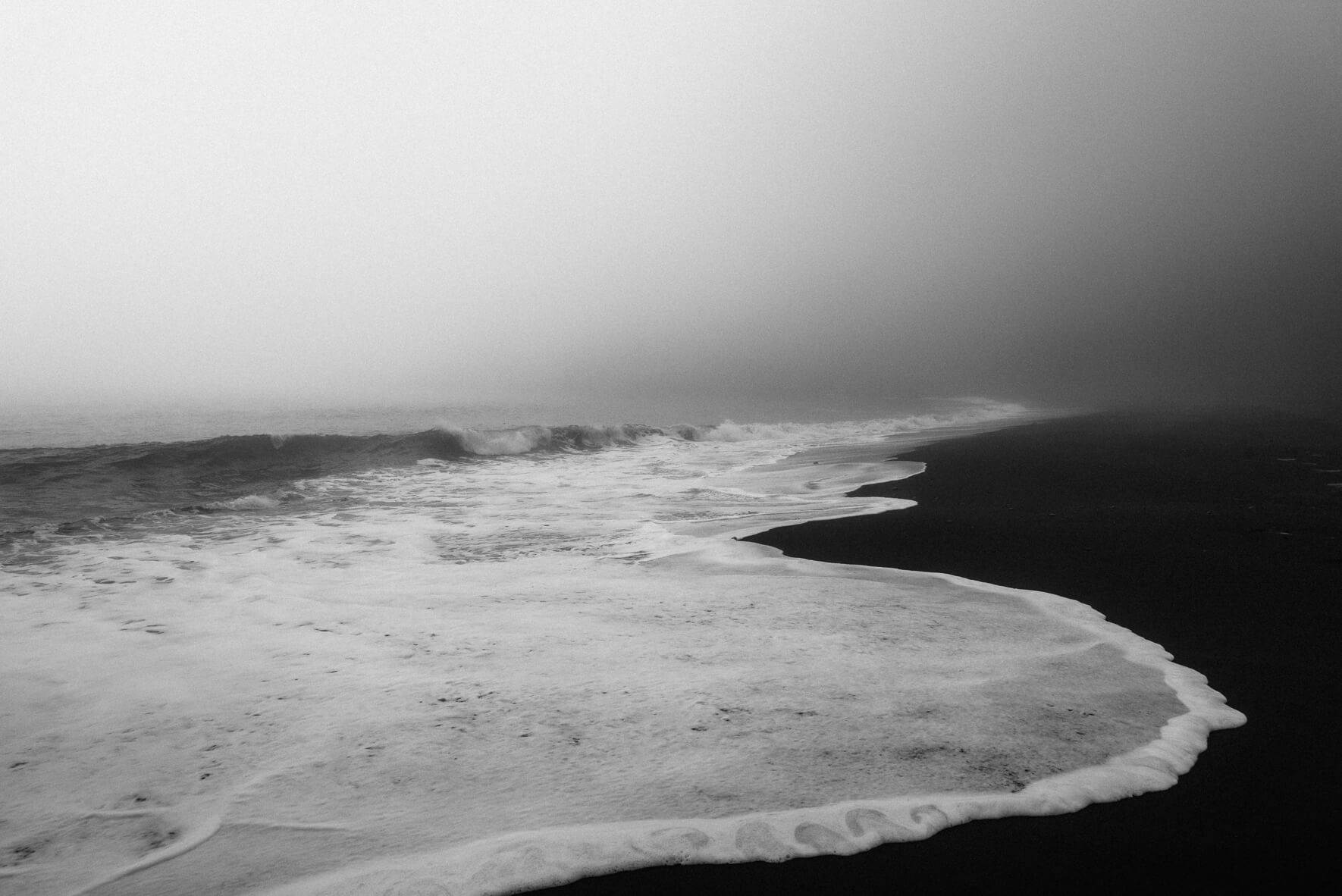 Waves crashing on the black sand beach of Vík í Mýrdal in Iceland