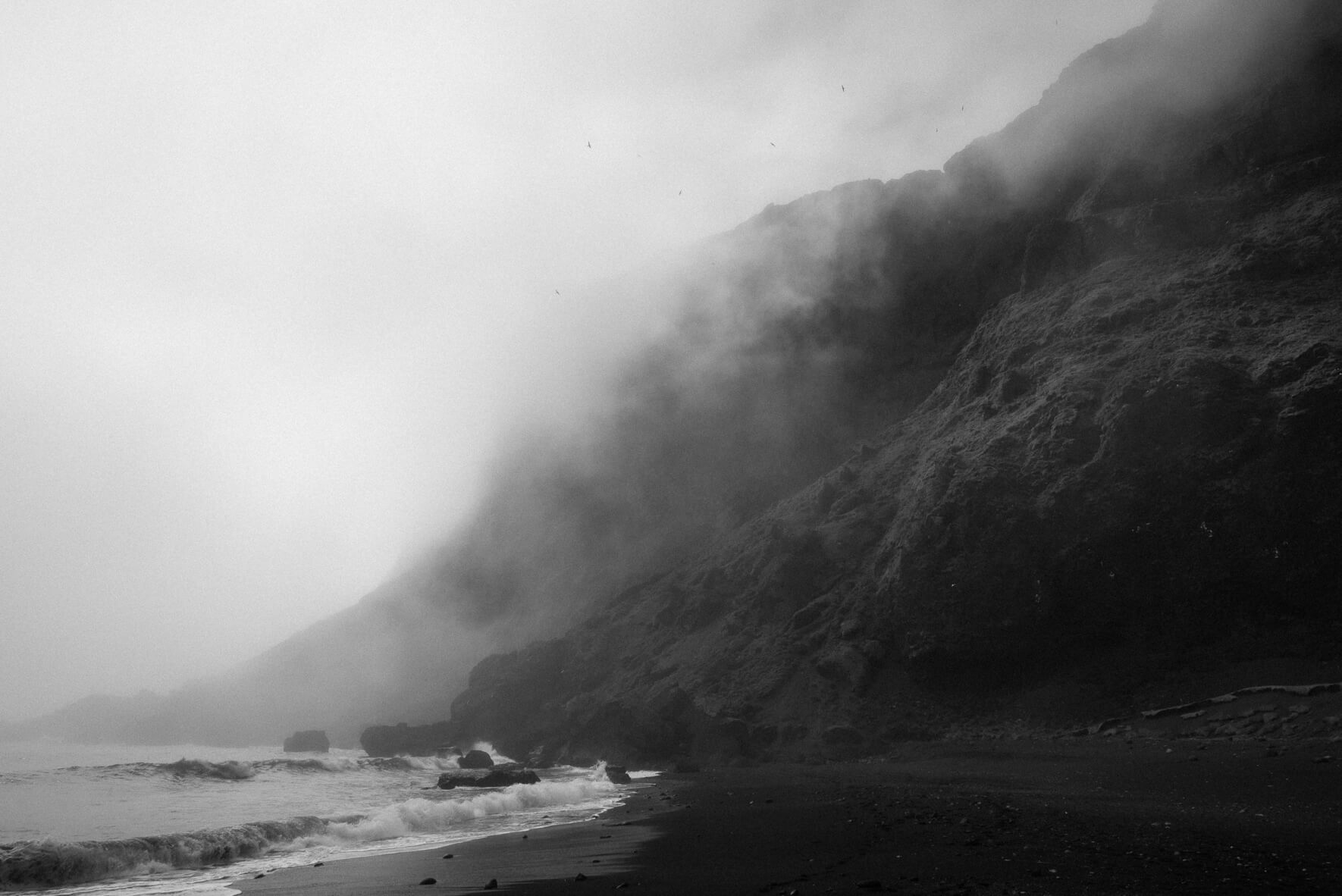 The cliffs on the black sand beach of Vík n Iceland on a foggy day (black & white)