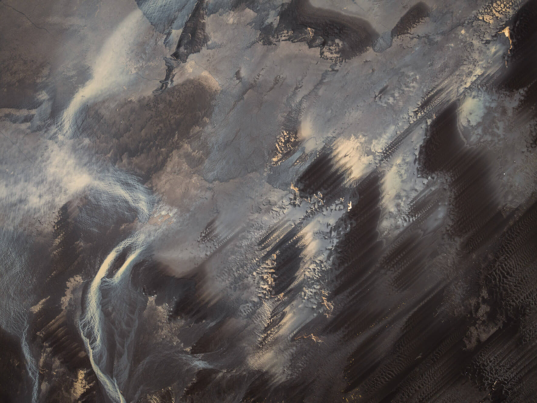 Aerial view of colorful tidal sand patterns in Iceland shaped by receding water