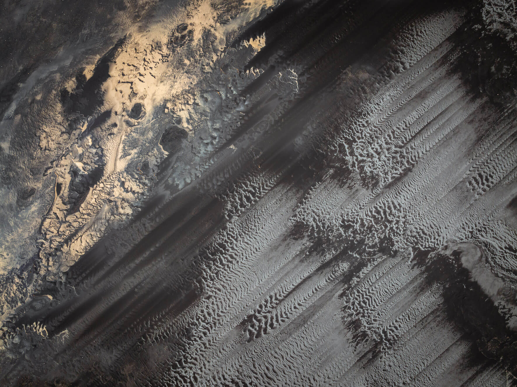 Abstract drone perspective of Iceland’s coastal sand textures formed by shifting currents