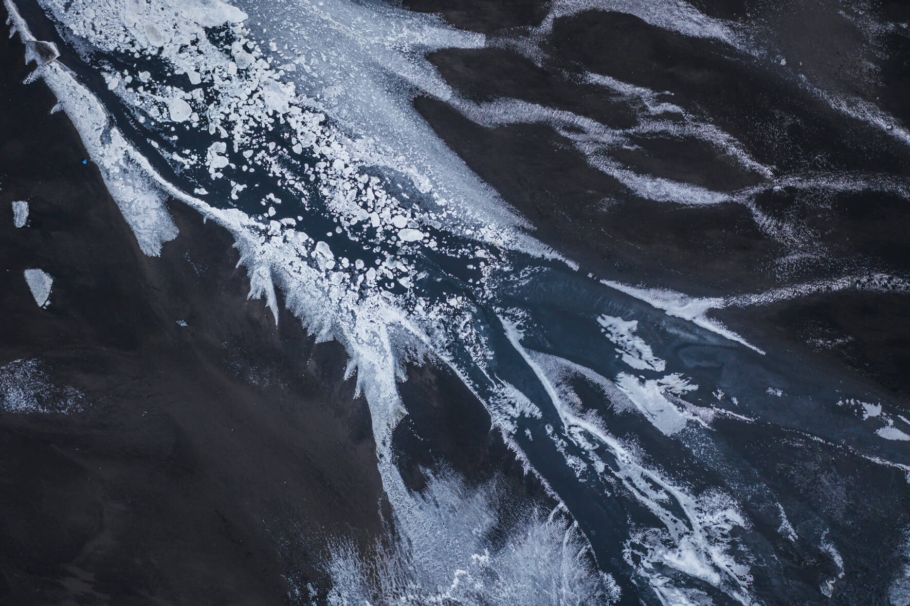 Aerial view of a glacier riverbed in Iceland with snow ice in winter