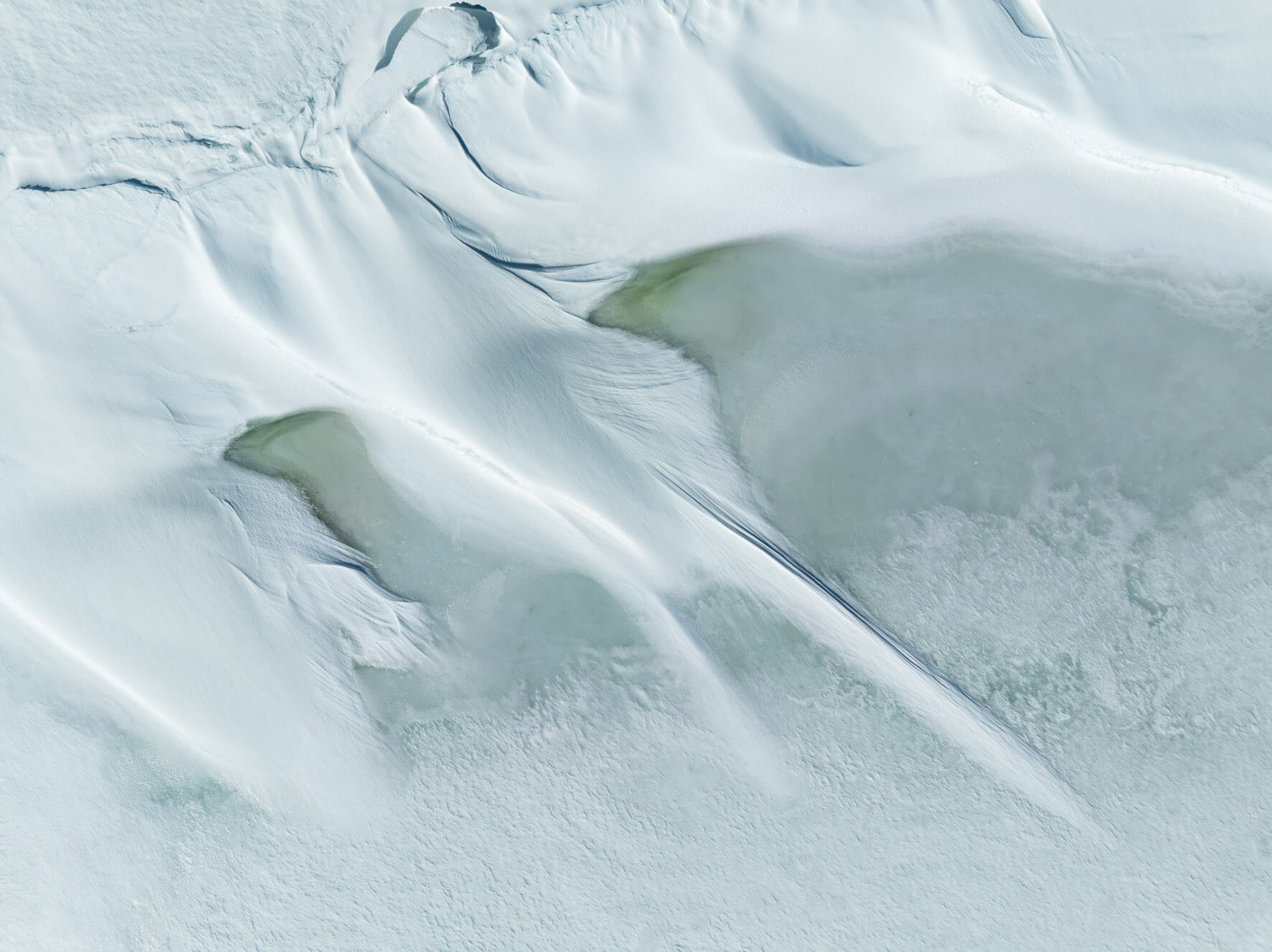 Aerial view of wind-blown snow patterns on a frozen lake in Hardangervidda Norway
