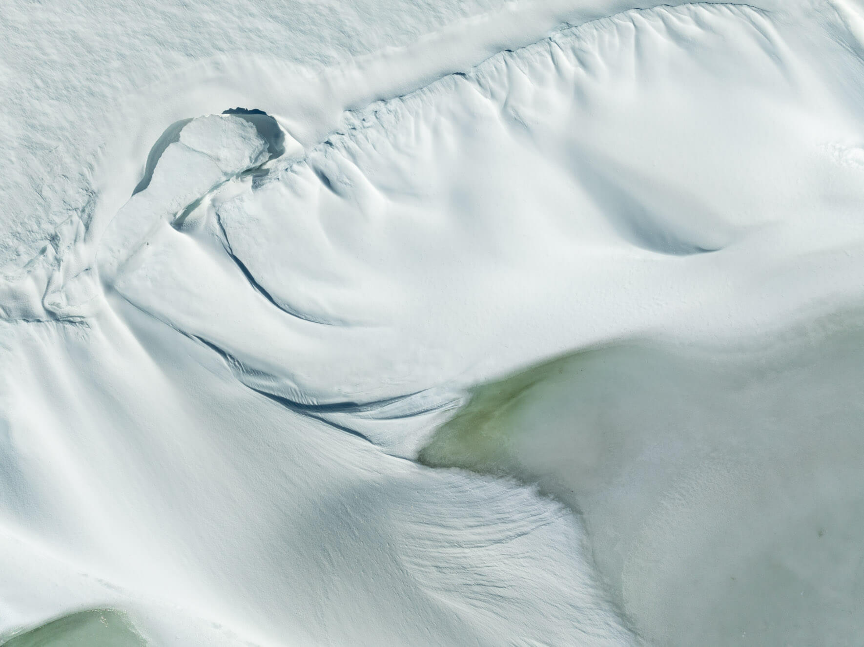 Aerial shot of wind-sculpted snow textures on Hardangervidda’s frozen winter landscape