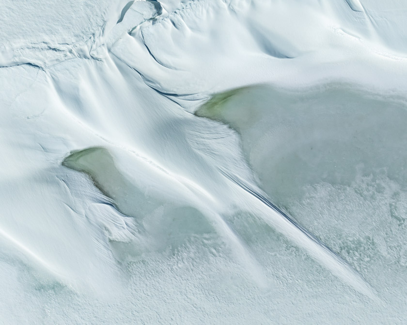 Aerial view of wind-blown snow patterns on a frozen lake in Hardangervidda Norway