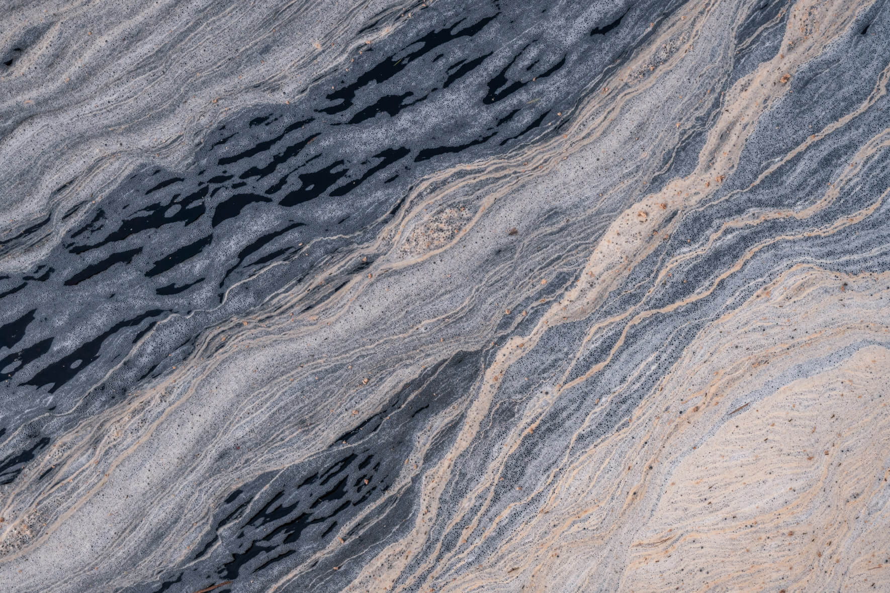 Close-up of swirling pollen formations on a small stream in southern Norway