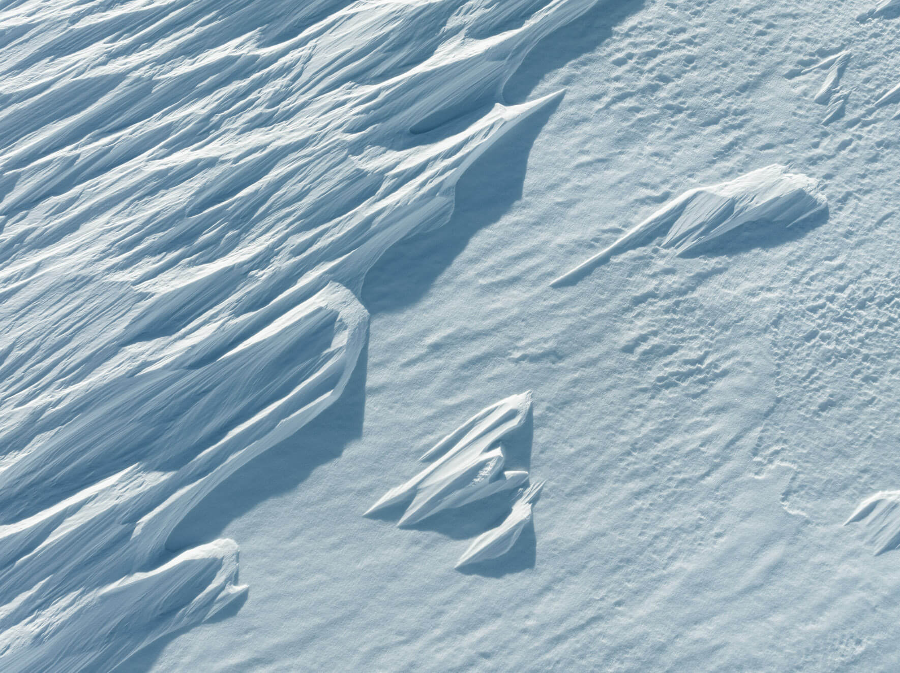 Close-up aerial view of delicate snow ridges shaped by powerful winds in Hardangervidda