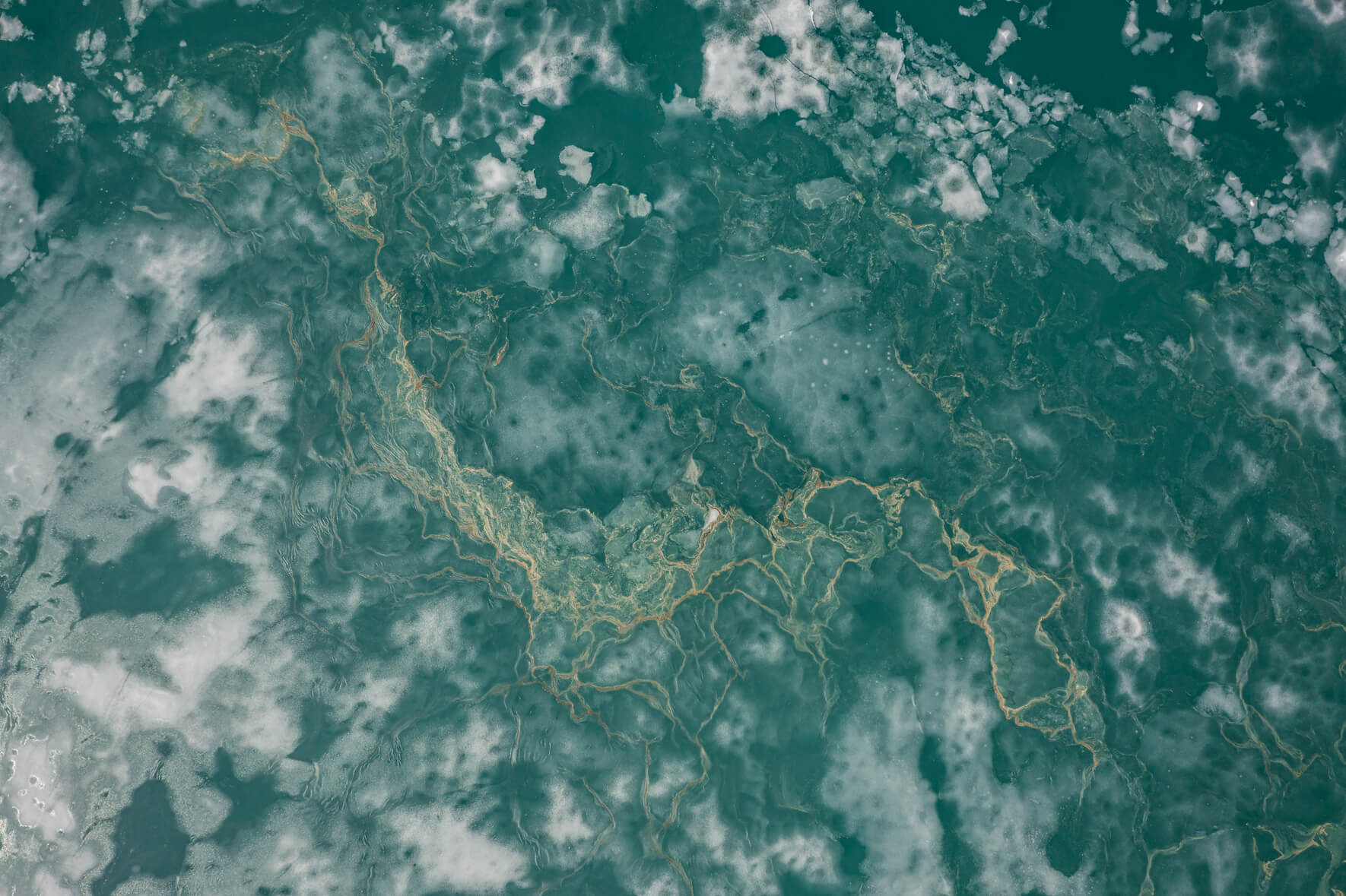 Abstract aerial photography of thawing lake in Norway with ice floes and snow