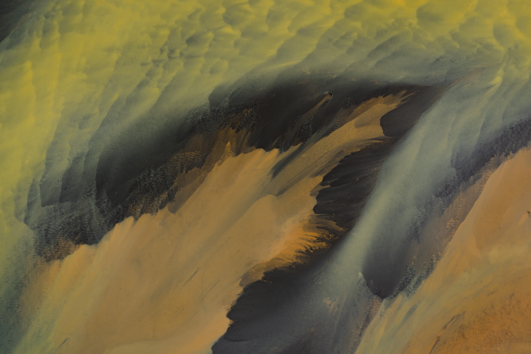 Aerial view of abstract yellow river with sediment island in Iceland