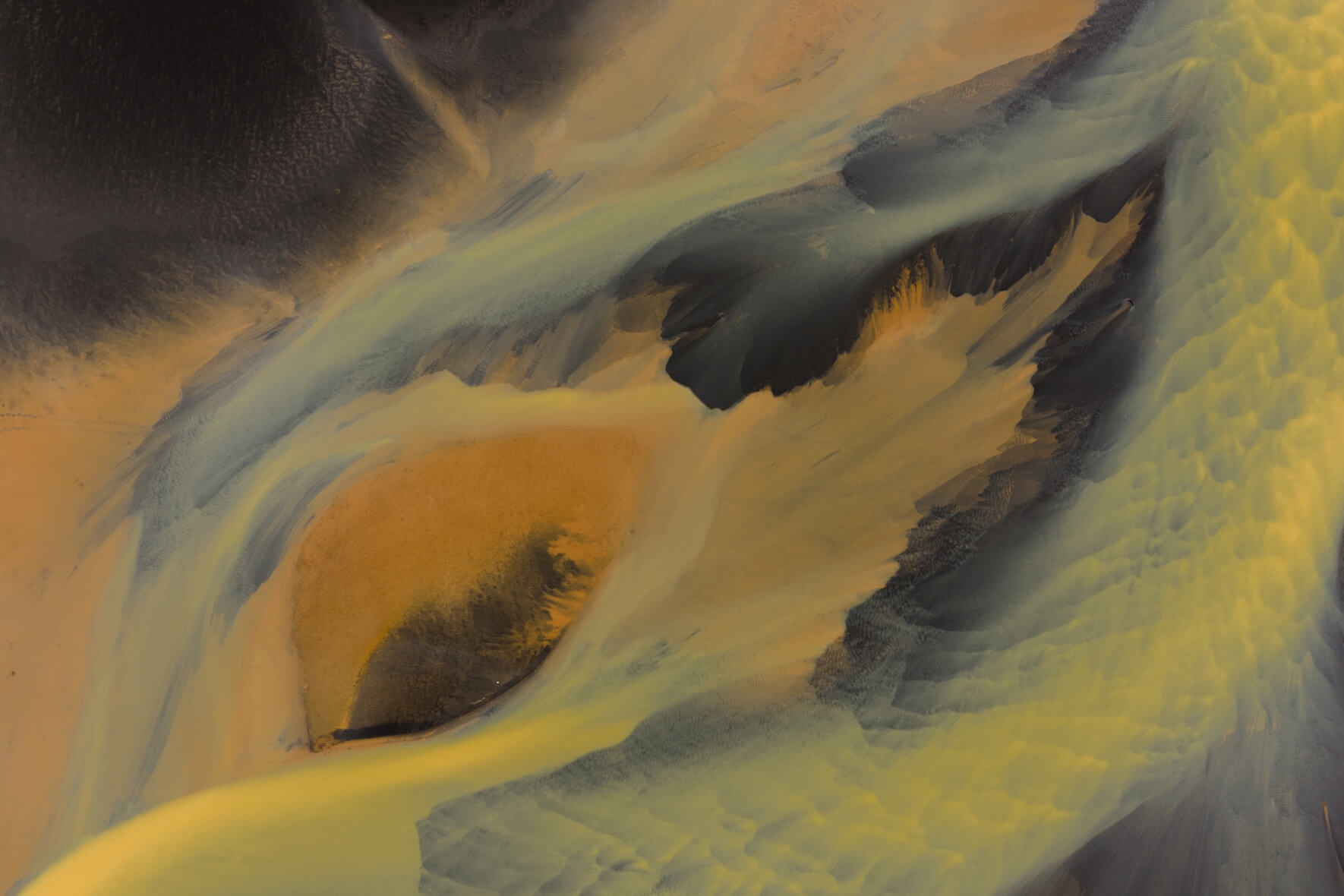 Aerial view of sulphur-stained waterways and dark sand islands in Iceland