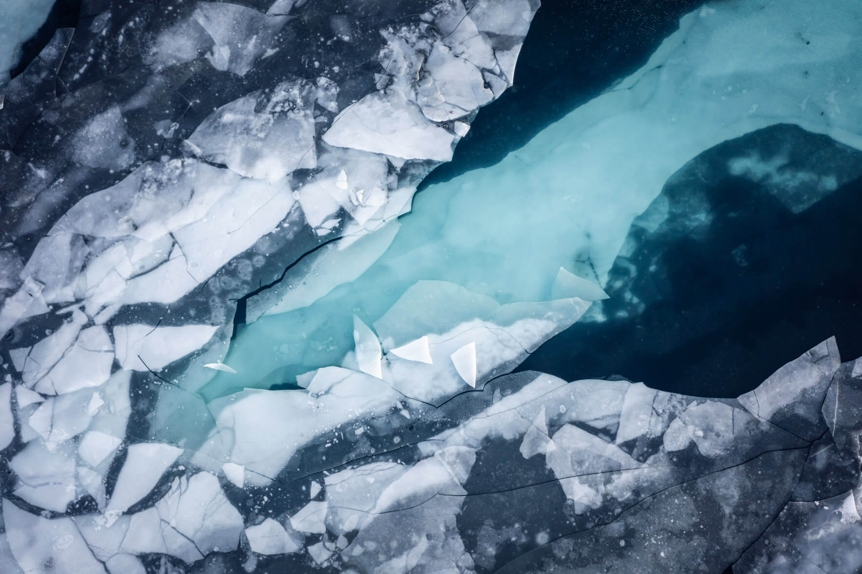 Aerial view of a thawing lake with ice floes on the surface