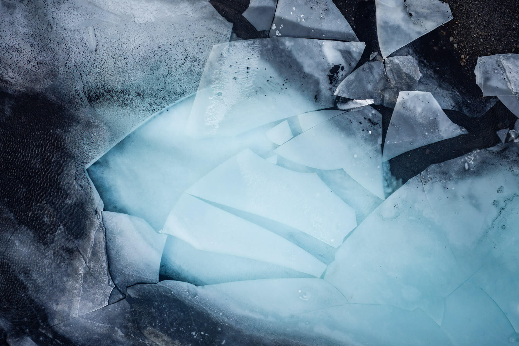 Aerial photography of a thawing lake in Iceland with large ice floes on the surface