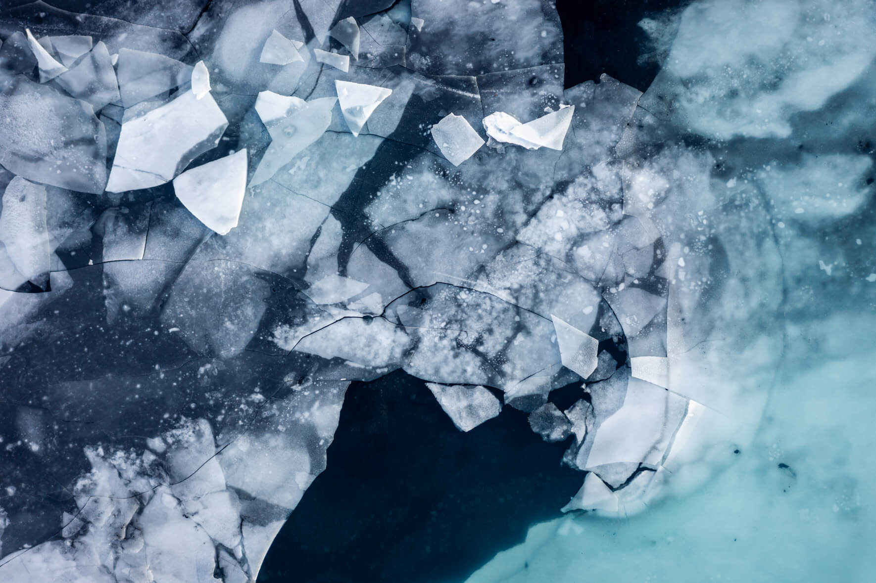 Aerial view of a thawing lake in Iceland with ice floes on the surface