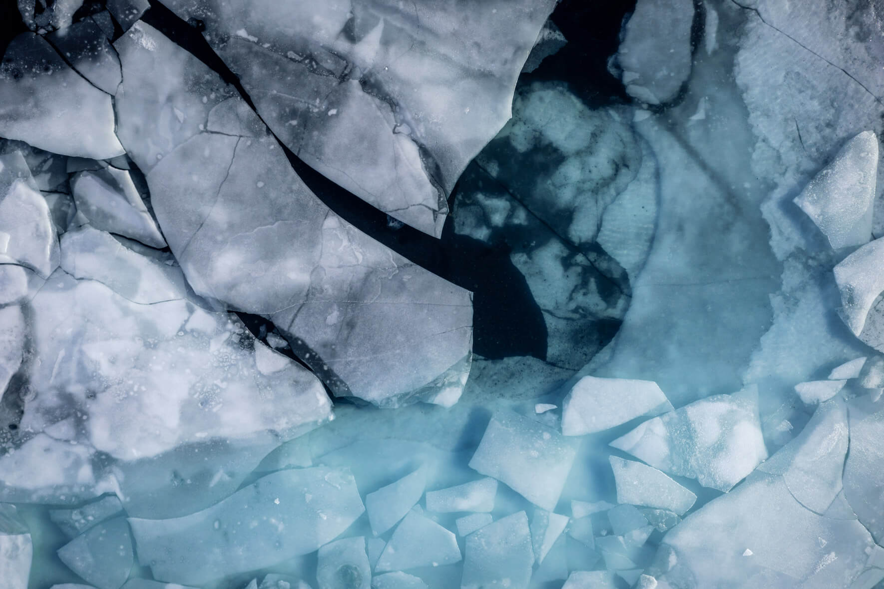 Aerial view of a thawing lake in Iceland with broken ice floes on the surface