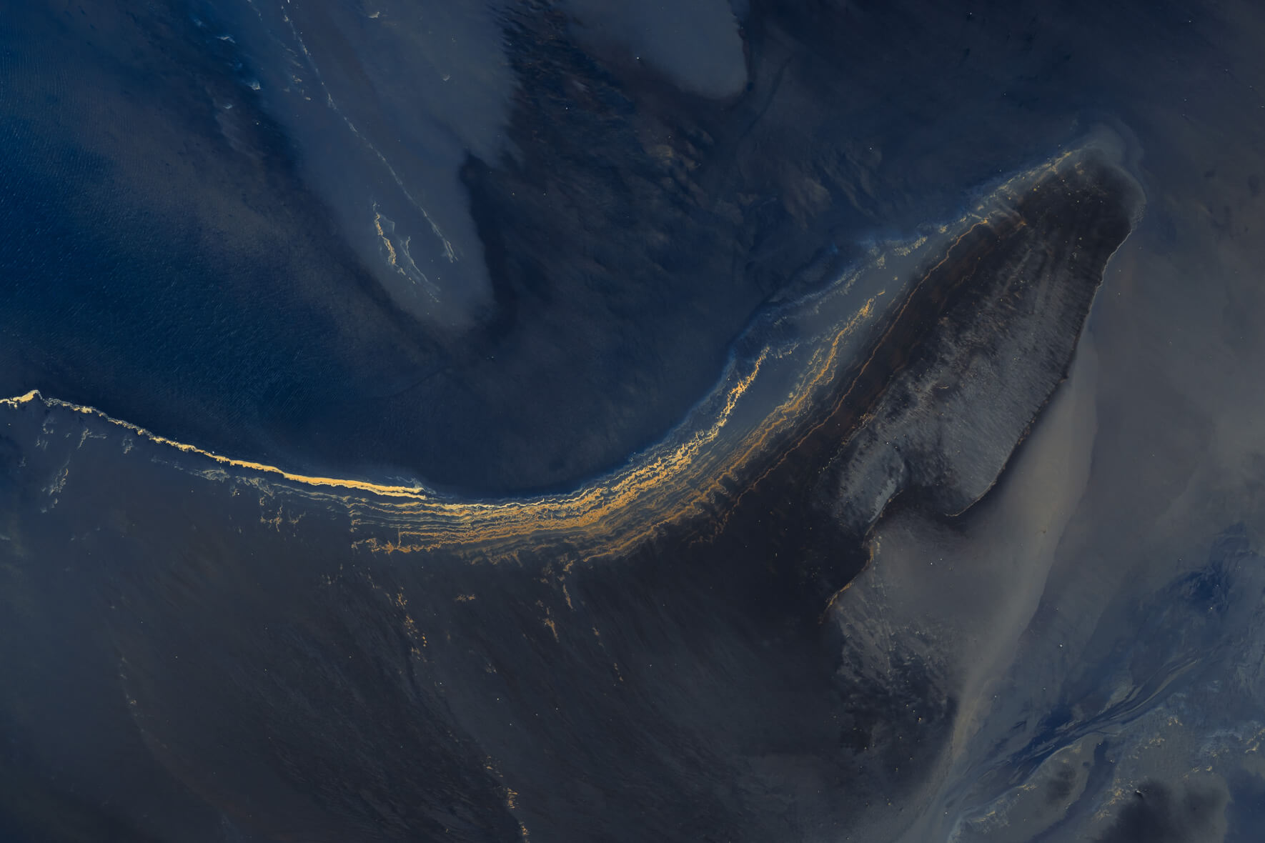 Aerial abstract of tidal seawater with shifting tones of blue and green