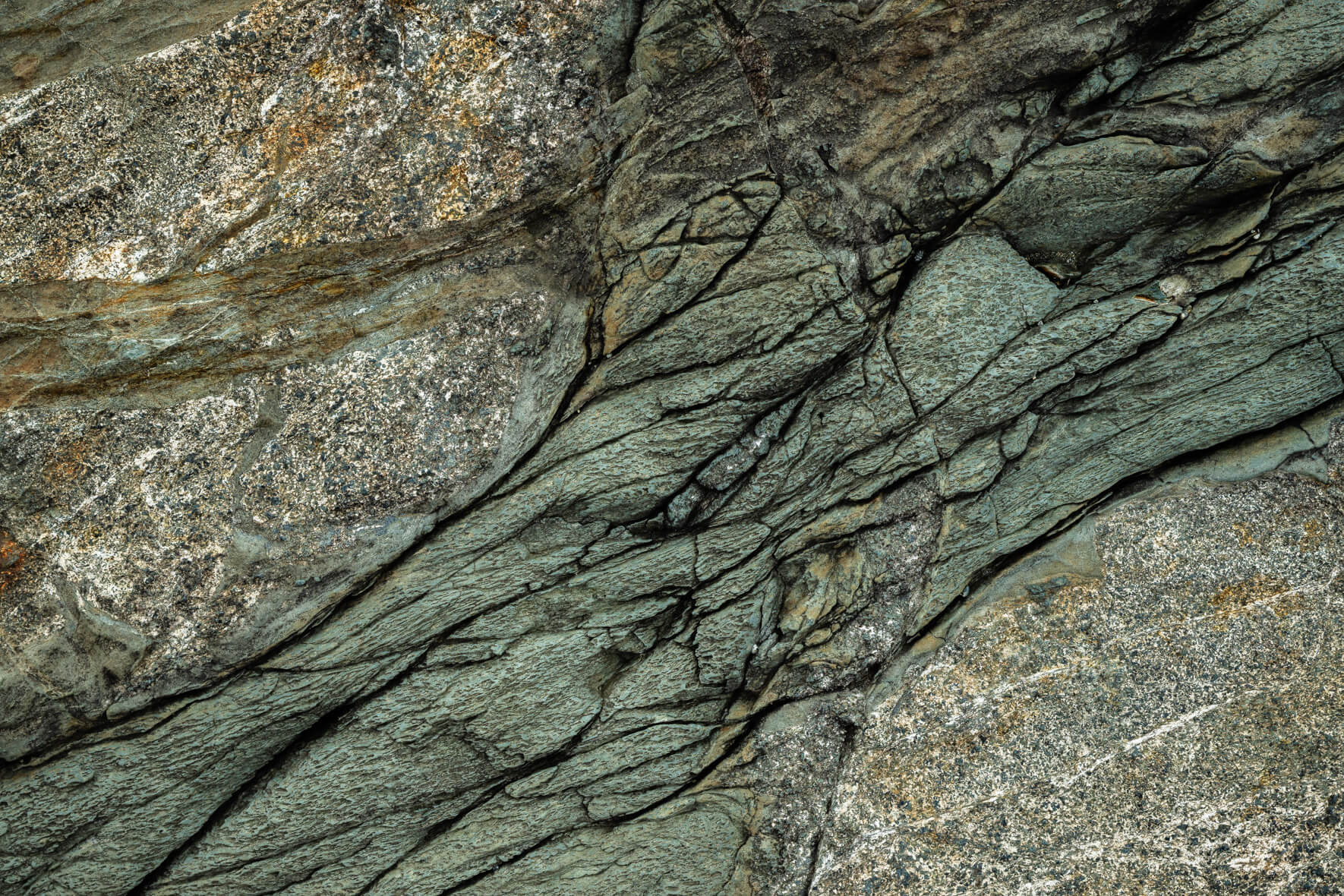Weathered rock formation with layered textures and dark oxidized details