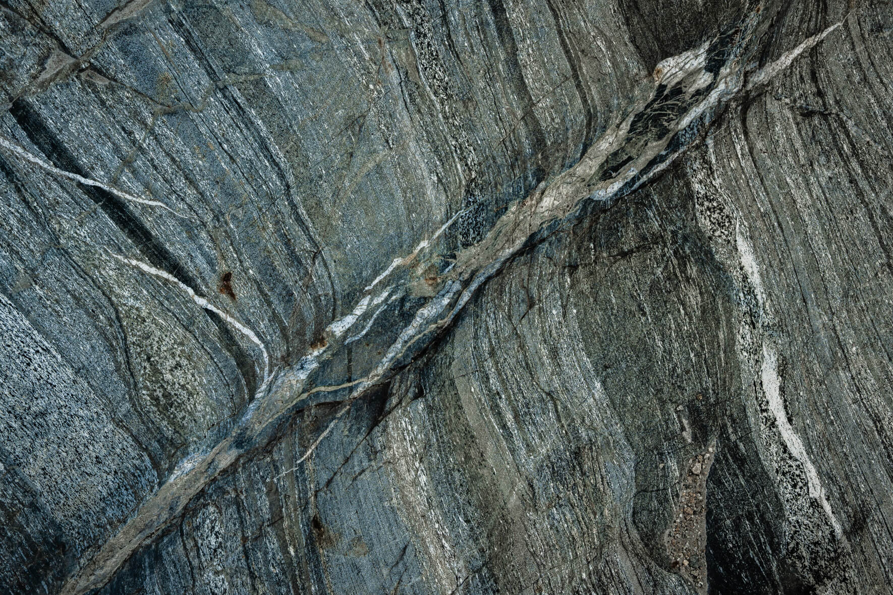Rock detail showing folded geological patterns in brown and gray hues