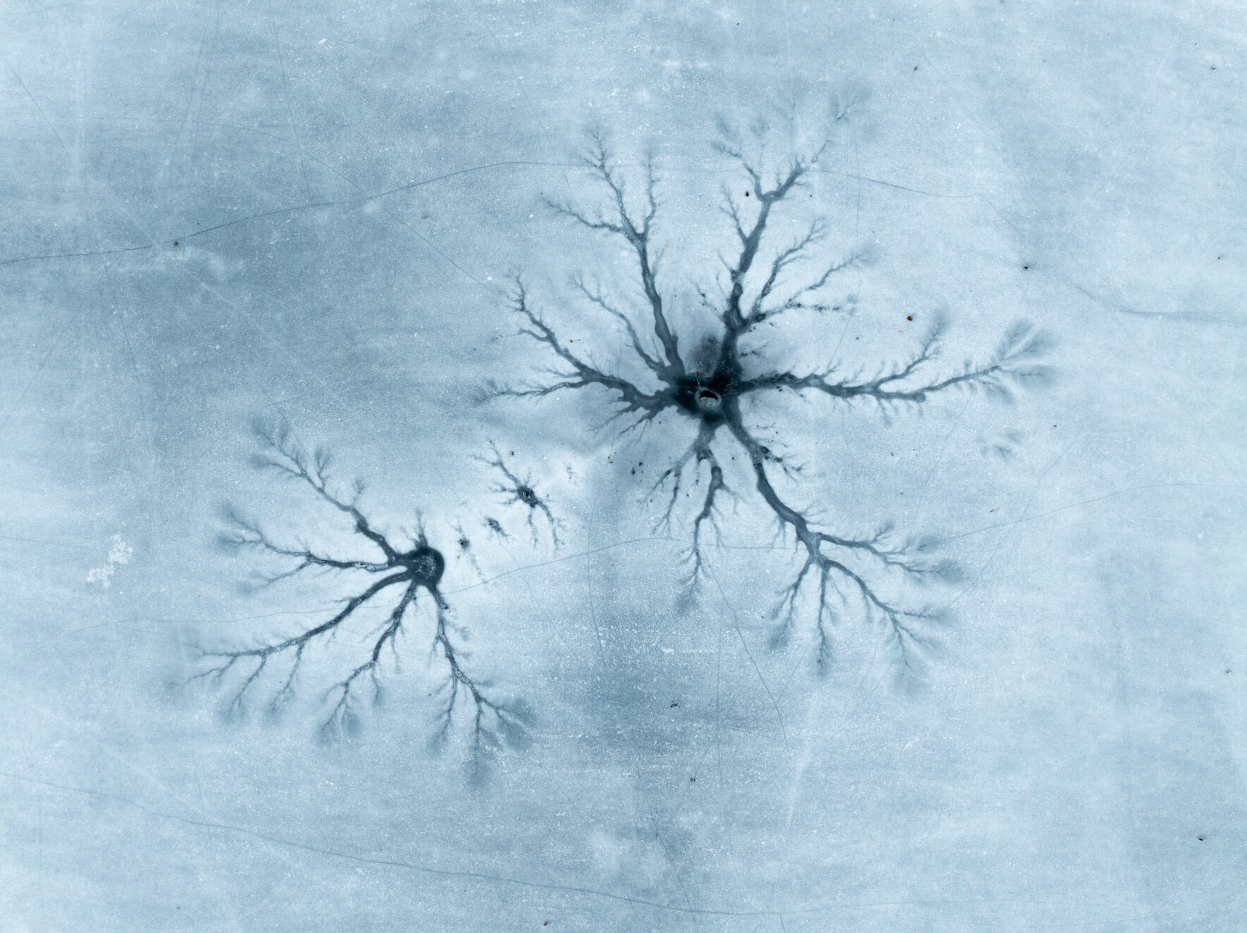 Curved ice formations creating subtle textures across a thawing lake in Norway