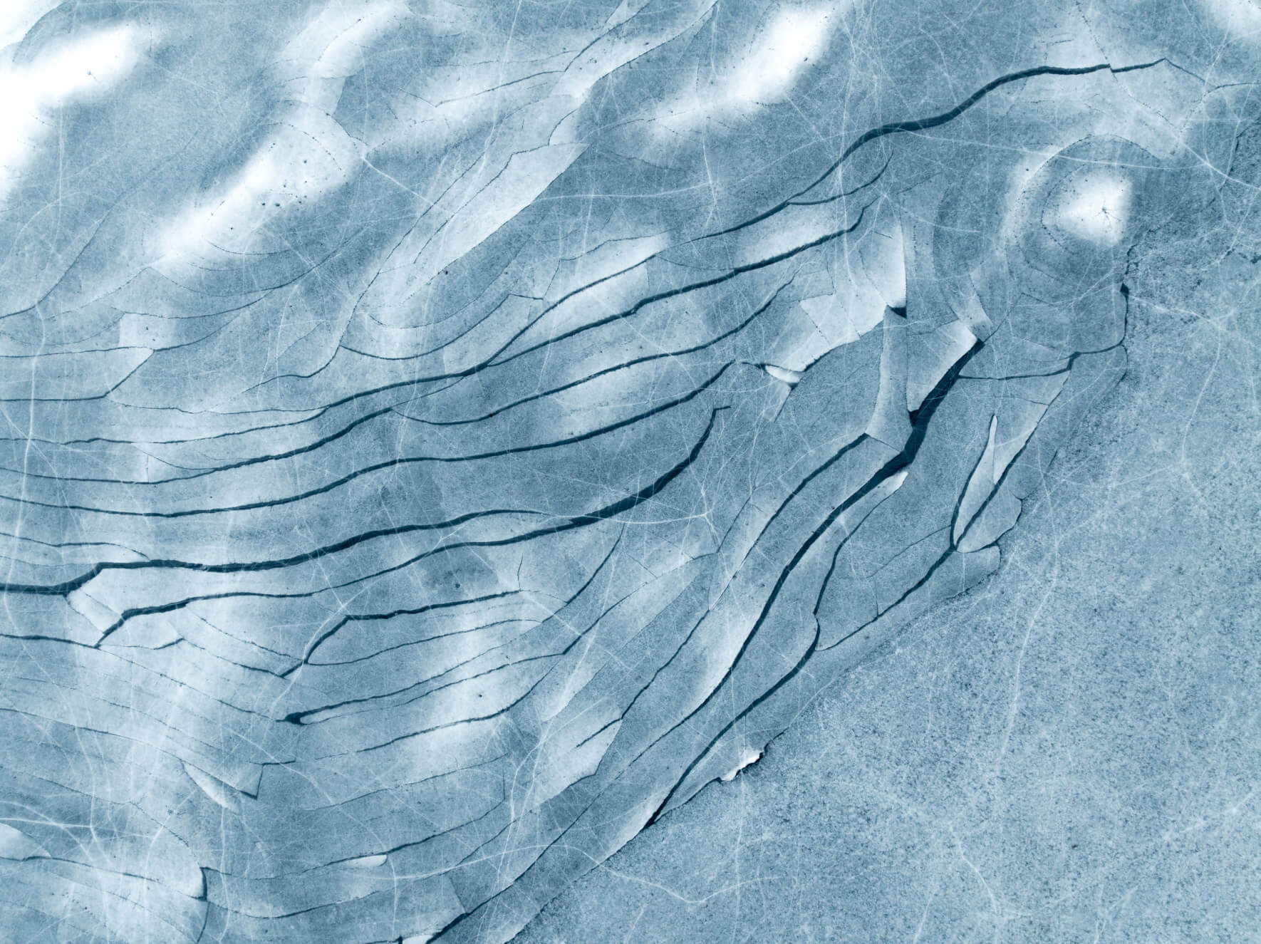 Winter scene of cracked ice plates forming abstract polygonal patterns in Norway