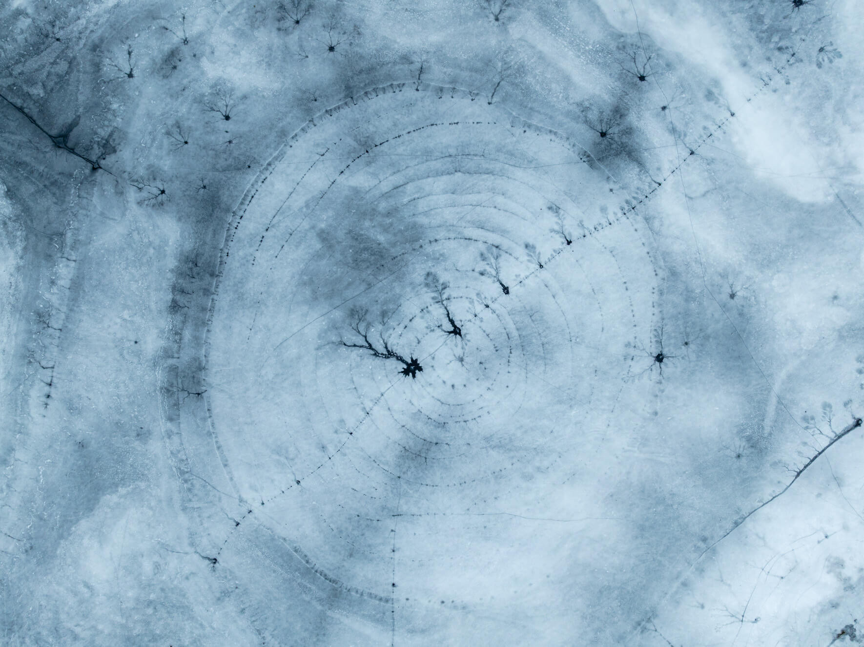 Frozen lake patterns shaped by wind, frost, and melting layers