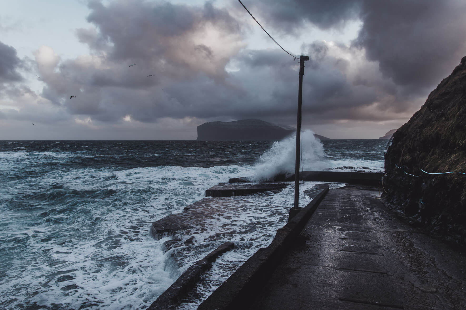 Waves crashing on the harbor of Viðareiði