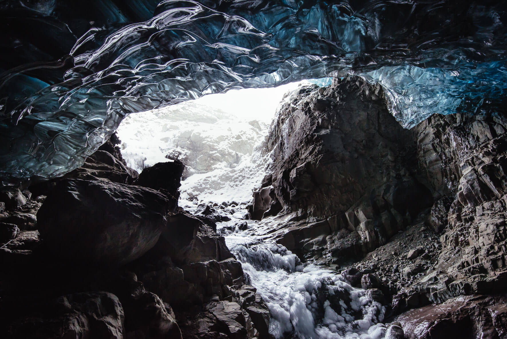 Vatnajökull glacier cave entrance with frozen river