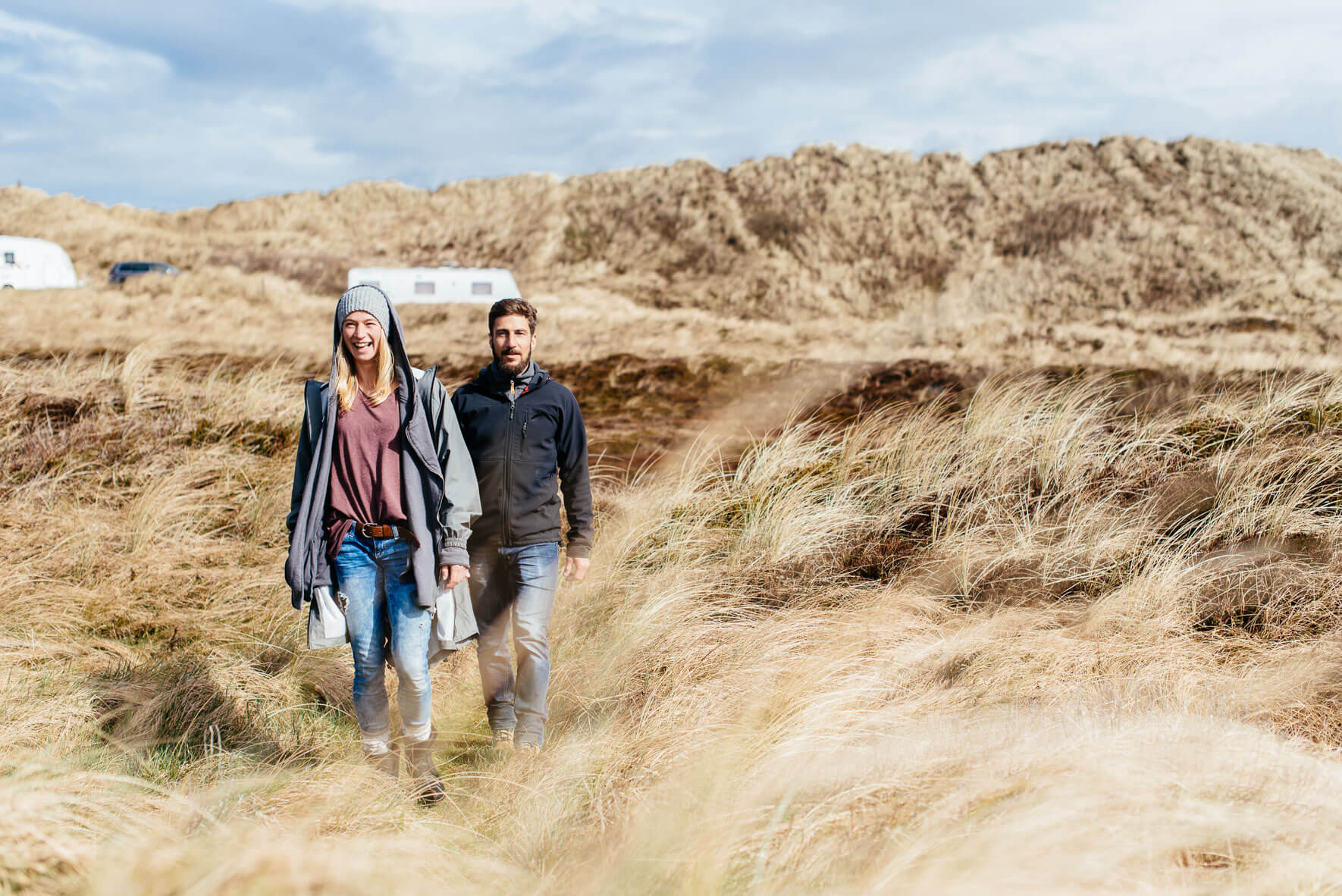 Young couple walking through dune landscape in Hvide Sande, Denmark