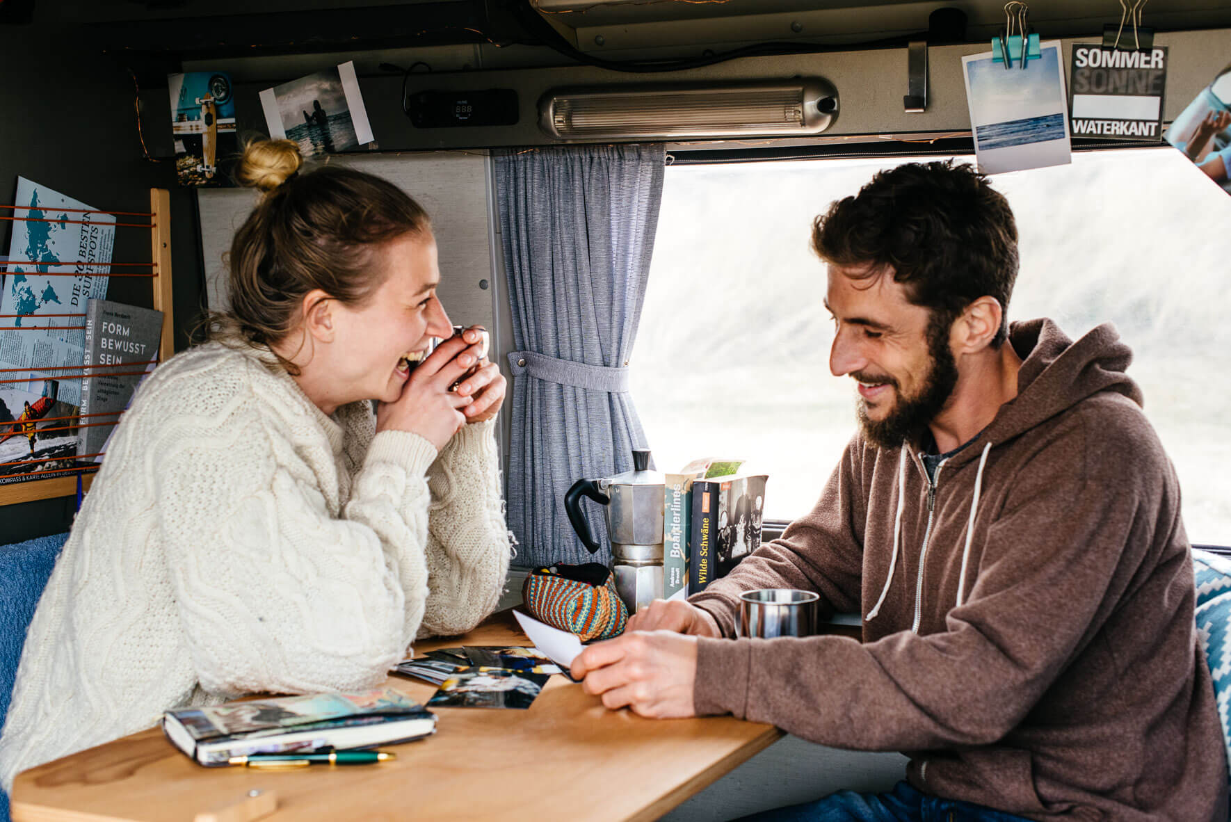 Friends taking a look at photos in camper van