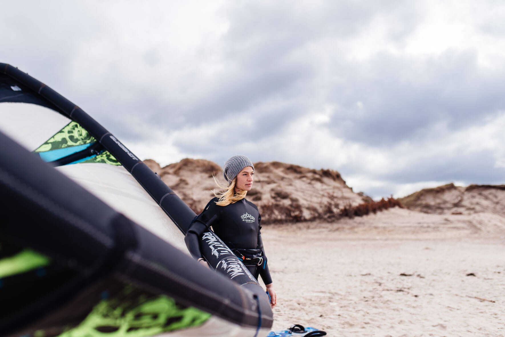 Woman with kite surf equipment on the beach