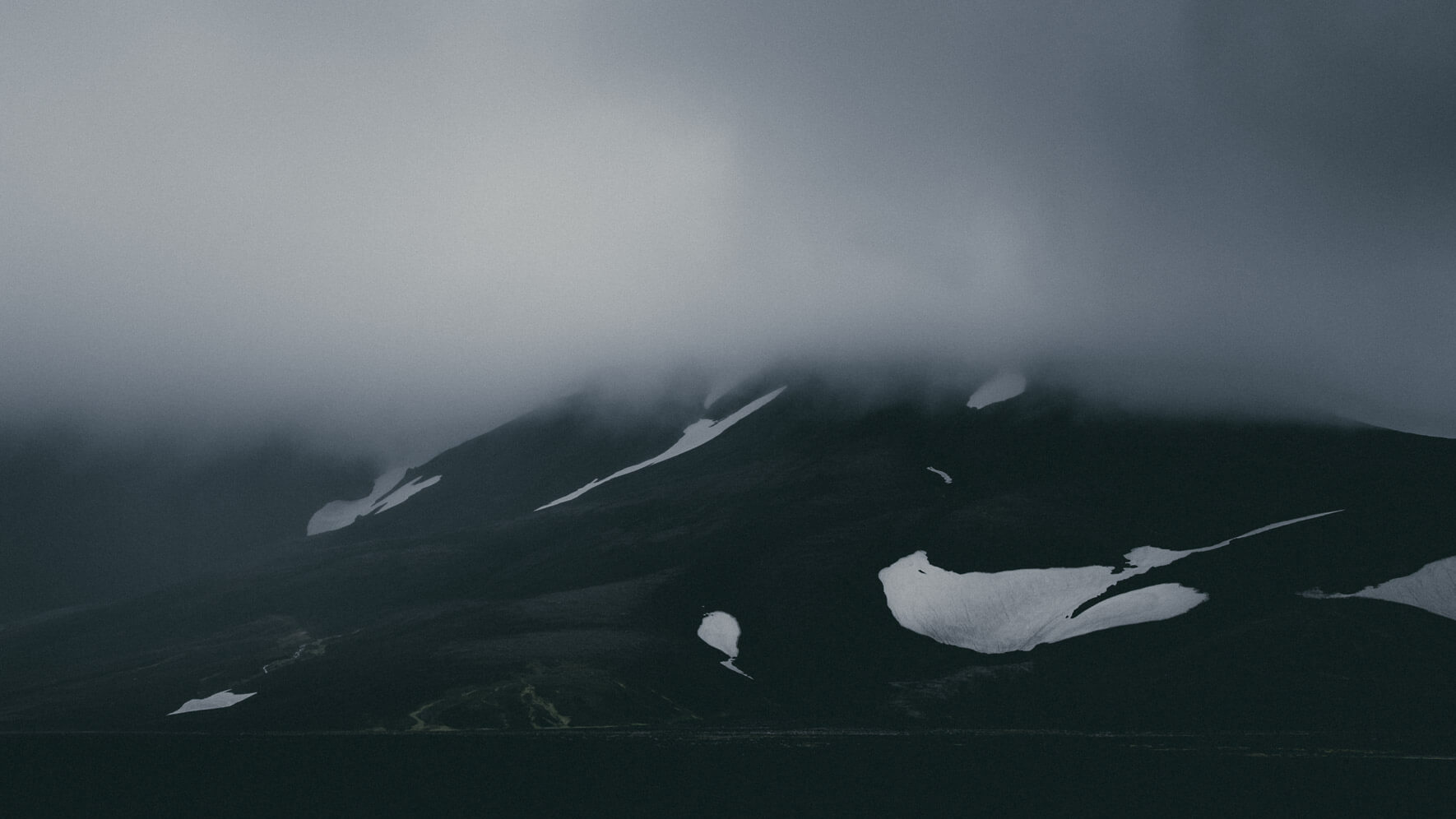 Snowy mountains in the clouds in the Highlands of Iceland