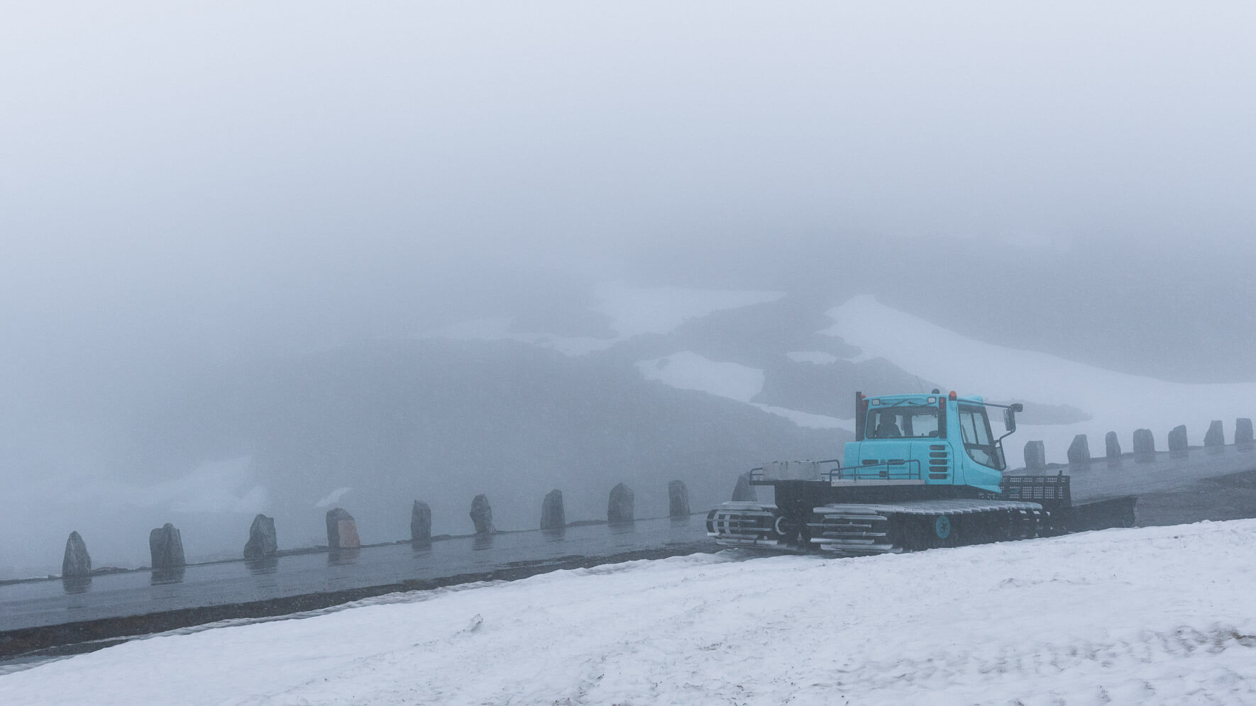Snow groomer along scenic road Gamle Strynefjellsvegen in Norway