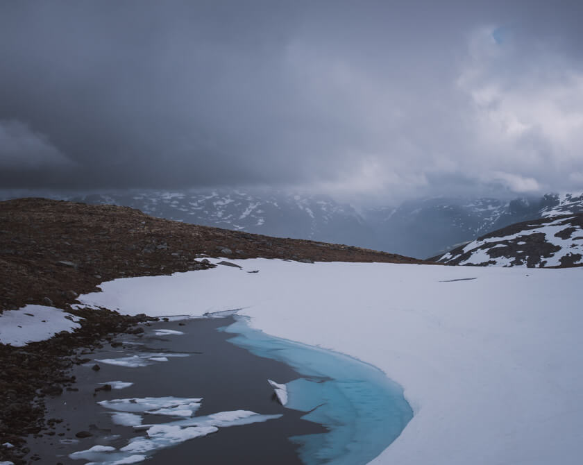 Moody weather with dark clouds over mountain lake in Norway