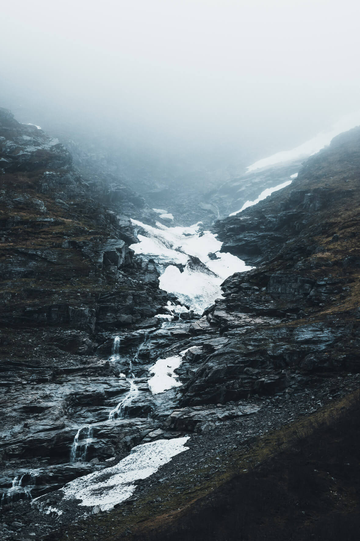 Foggy scene in the mountains with waterfall (Jostedal, Norway)