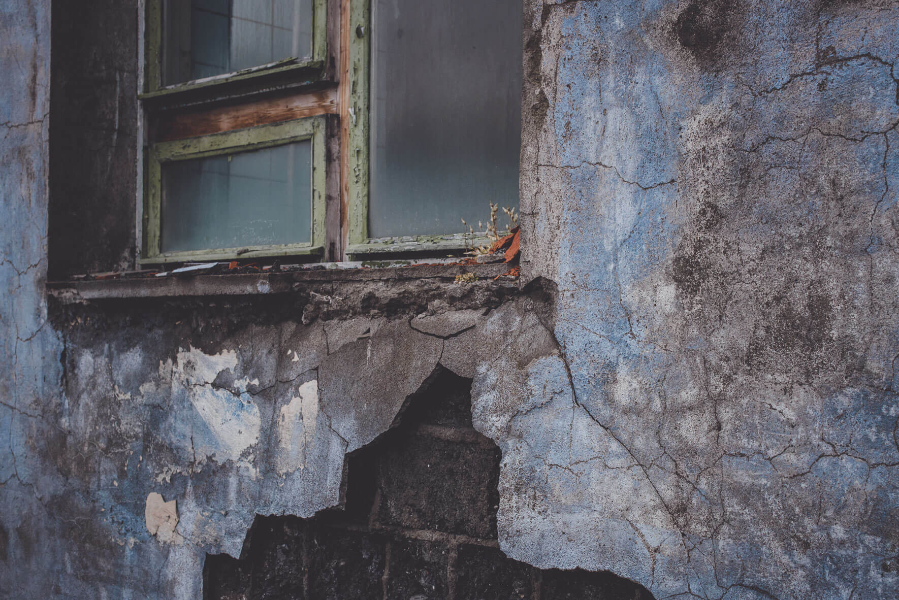 Broken window of a building of the Russian coal-mining settlement Pyramiden on the archipelago of Svalbard, Norway